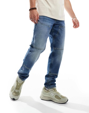 ASOS DESIGN tapered jeans in mid blue wash with carpenter details