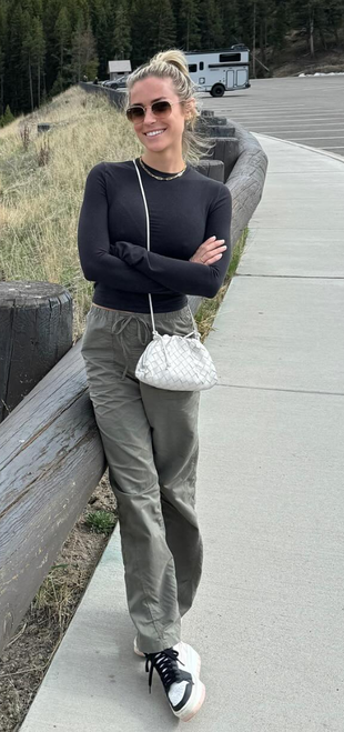 sunglasses, white woven handbag, green pants, sneakers, jewelry, and black long sleeve top?