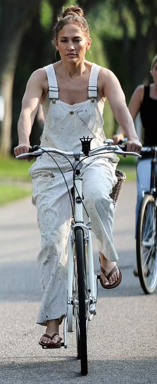 beige paint splatter overalls, brown flip flops, and hoop jewelry?