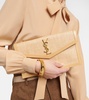 Uptown leather-trimmed raffia clutch